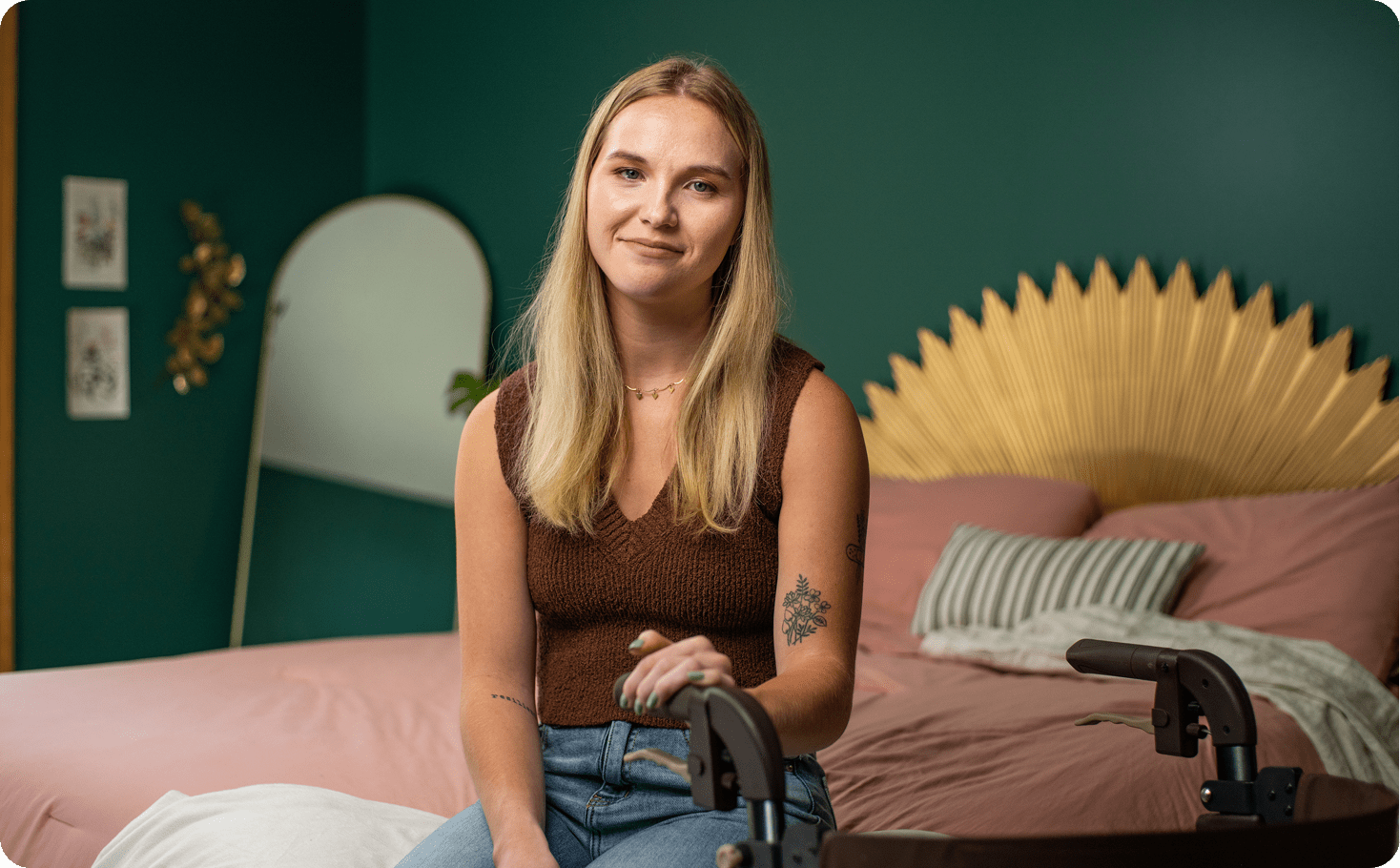 Woman with Friedreich ataxia sitting in a bedroom, smiling